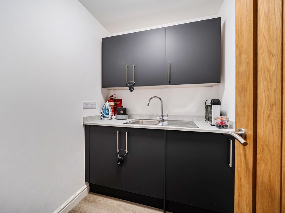 A utility room with a sink and cabinets at Buttercup Cottage St Merryn