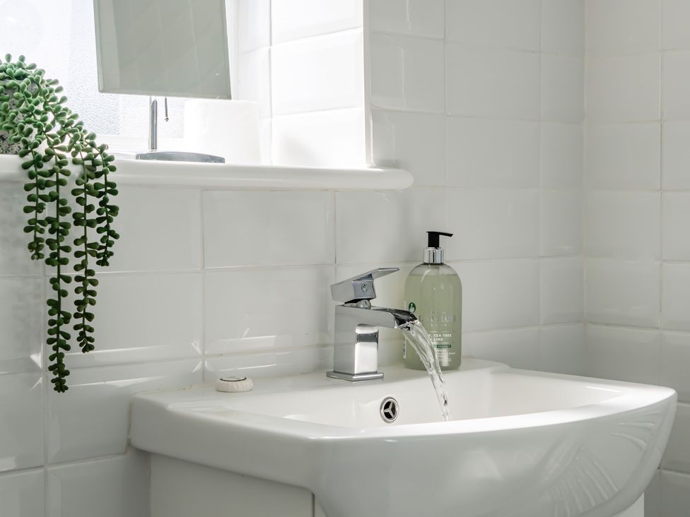 A sink with a tap and soap dispenser at Buttercup Cottage in St Merryn