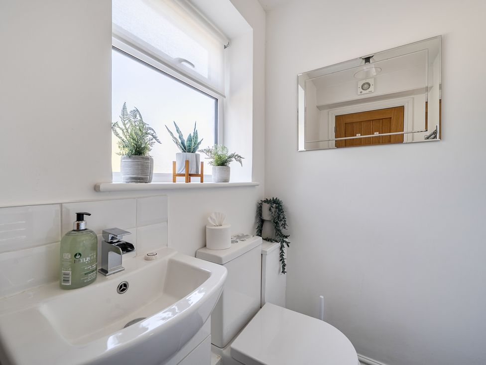 A bathroom with a sink and toilet at Buttercup Cottage St Merryn