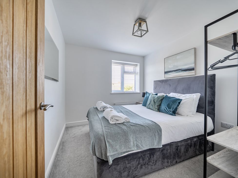 A bedroom with a bed and window at Buttercup Cottage St Merryn
