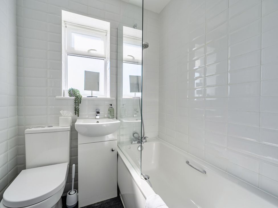 A bathroom with a shower and bathtub at Buttercup Cottage in St Merryn