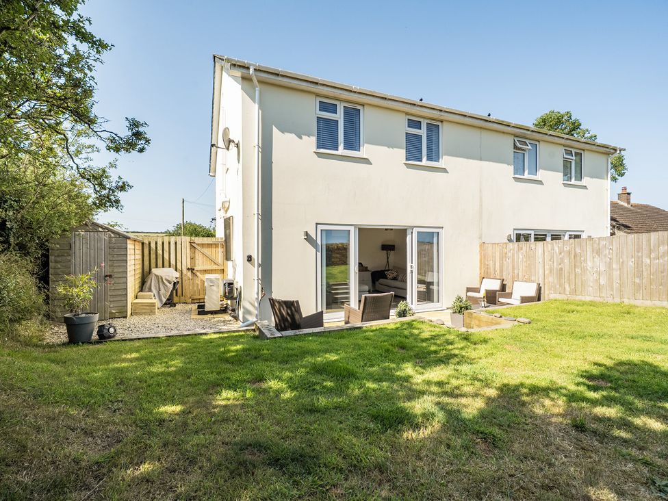 A house with a garden and seating area at Buttercup Cottage in St Merryn