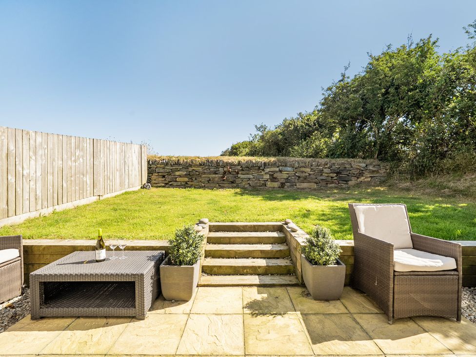 A garden with steps and furniture at Buttercup Cottage in St Merryn