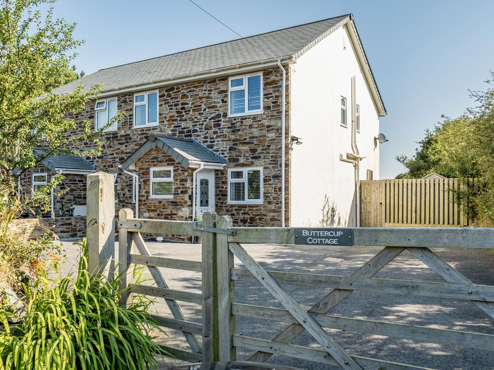 A house with stone exterior and gate at Buttercup Cottage St Merryn