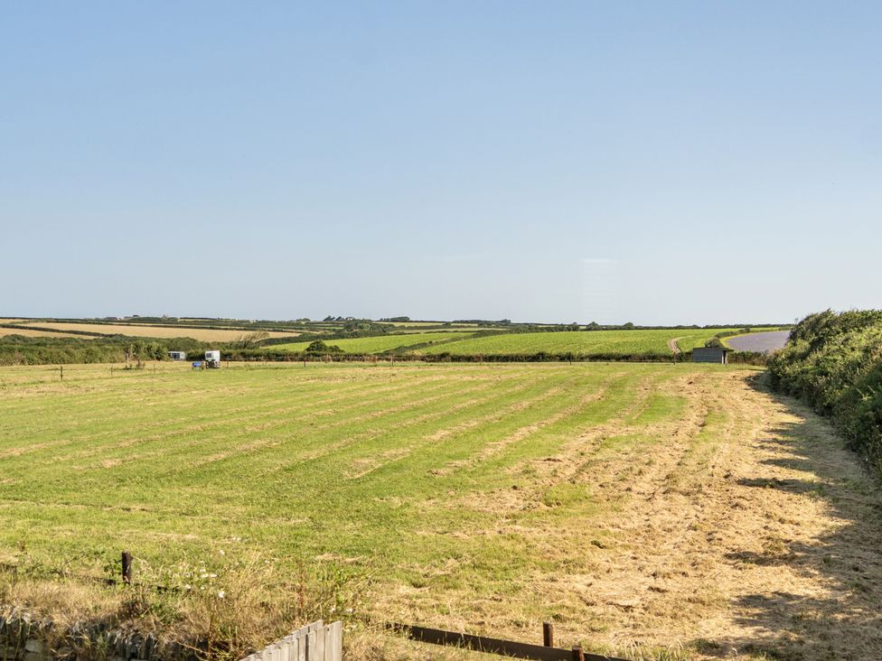 A field with a tractor and a road at Buttercup Cottage in St Merryn
