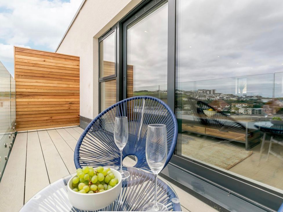 A balcony with a table and glasses at Seascape in Newquay