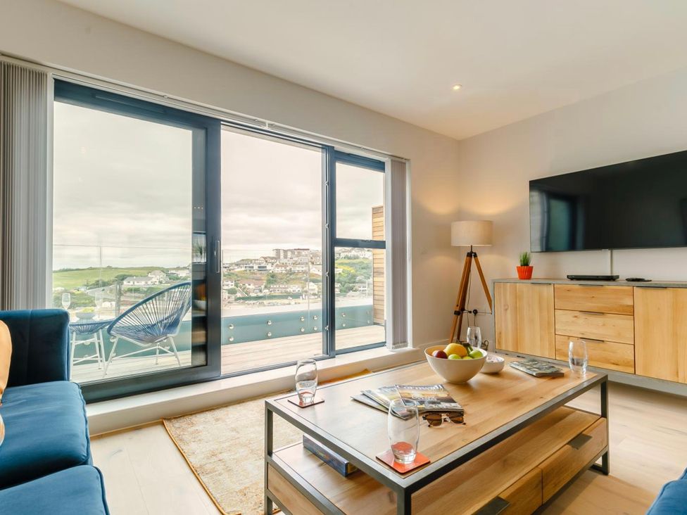 A living room with a television and sliding doors at Seascape in Newquay
