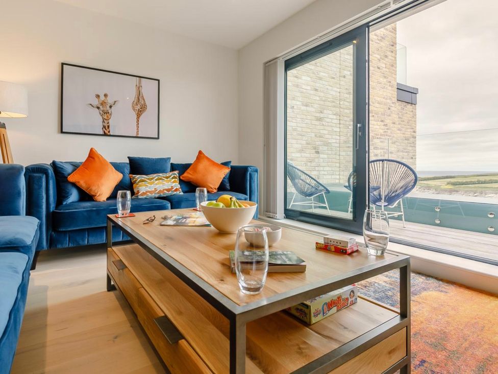 A living room with a sofa and coffee table at Seascape in Newquay