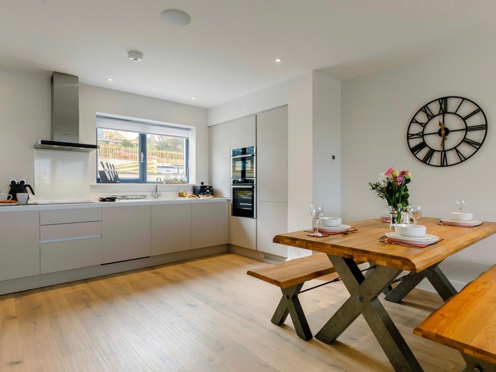 A kitchen with a dining table and chairs at Seascape in Newquay
