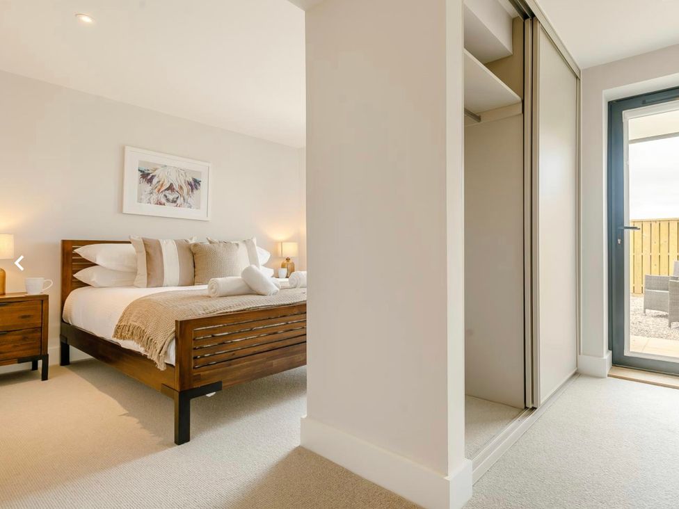 A bedroom with a bed and nightstand at Seascape in Newquay