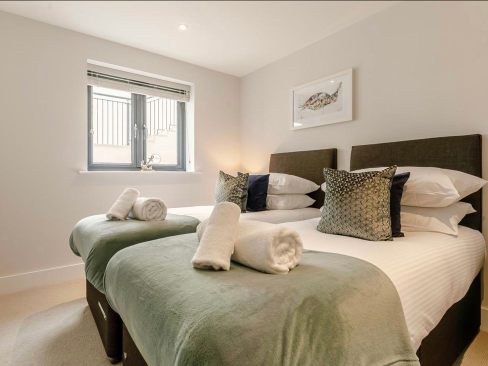 A bedroom with two beds and a window at Seascape in Newquay