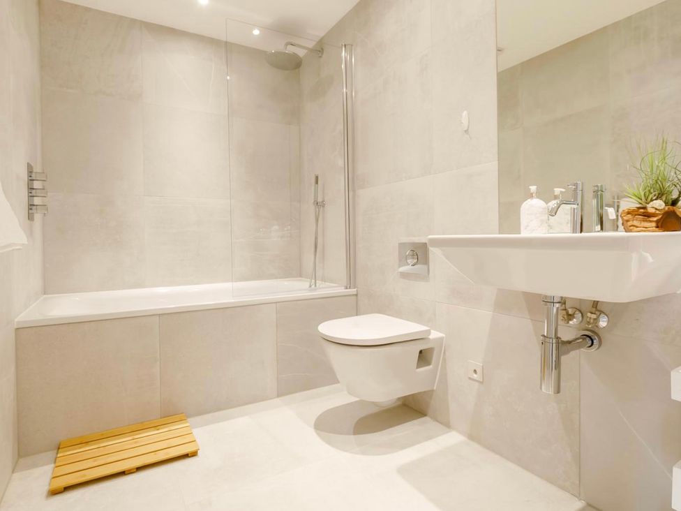 A bathroom with a bathtub, toilet, and sink at Seascape in Newquay