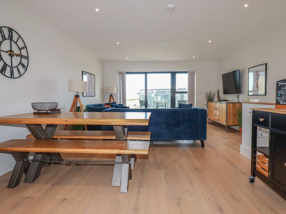 A living room with a dining table and sofa at Seascape in Newquay