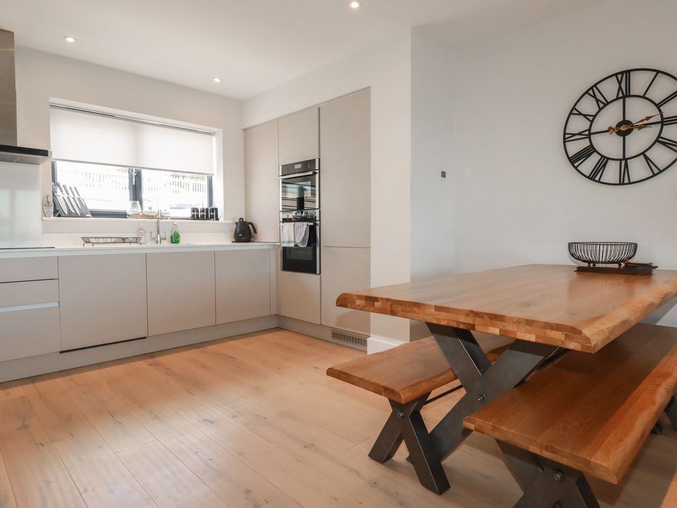 A kitchen with a table and chairs at Seascape in Newquay