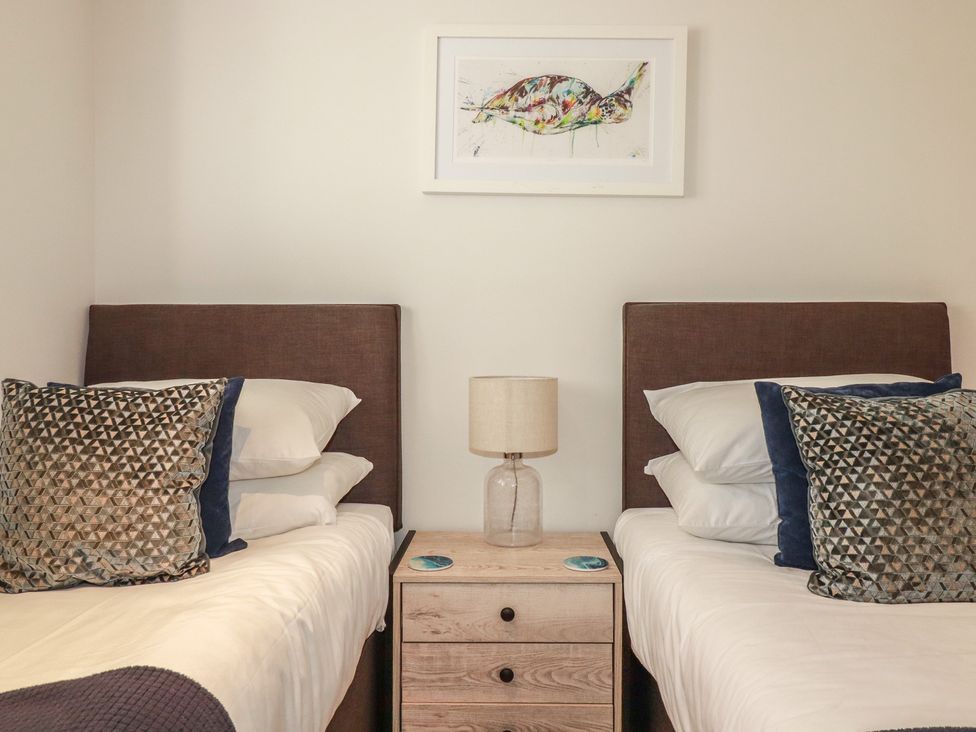 A bedroom with two beds and a lamp at Seascape in Newquay