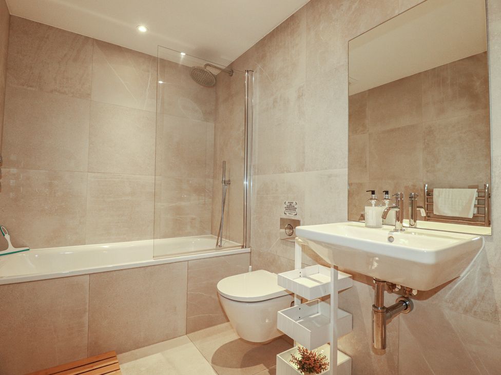 A bathroom with a bathtub, shower, toilet, and sink at Seascape in Newquay