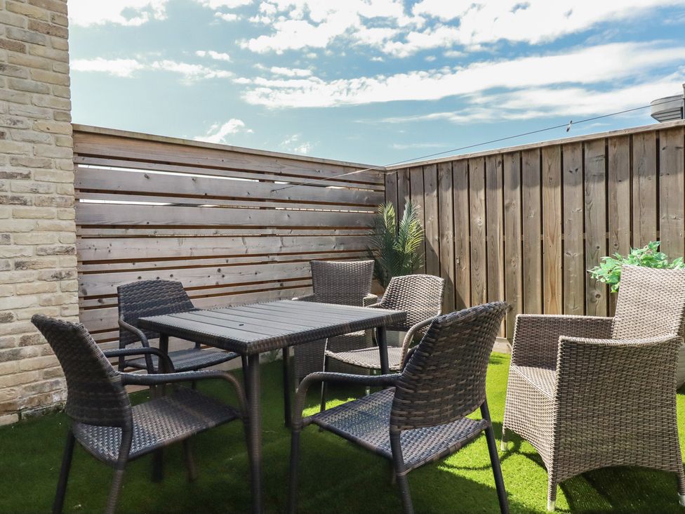 An outdoor seating area with a table and chairs at Seascape in Newquay