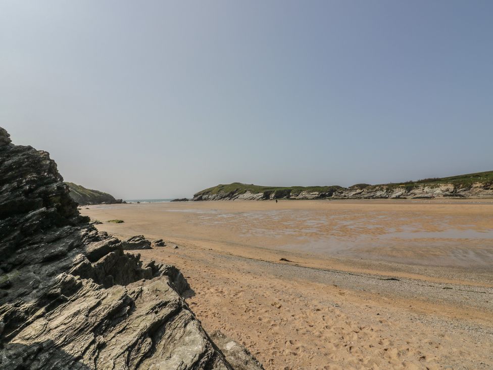 A rocky beach with sand and water at Seascape in Newquay