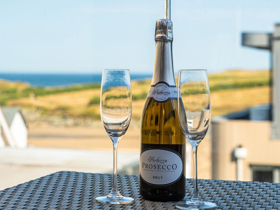 A bottle of prosecco and two glasses on a table at Seascape in Newquay