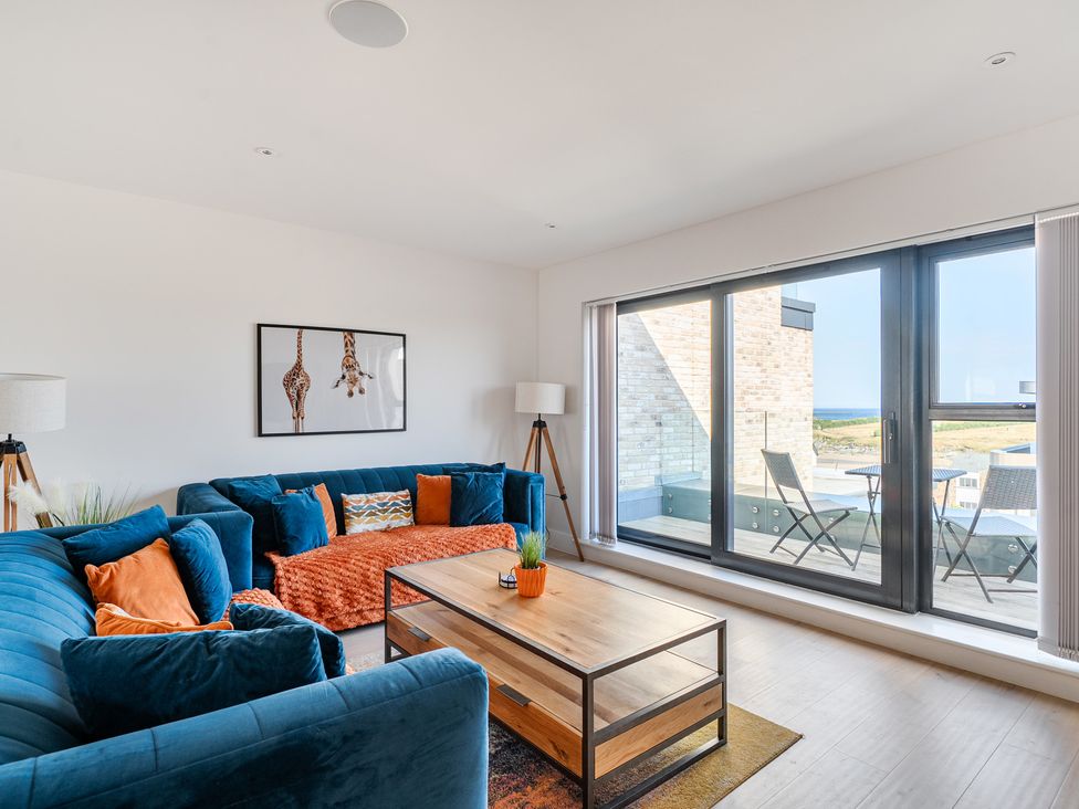 A living room with a sofa and coffee table at Seascape in Newquay