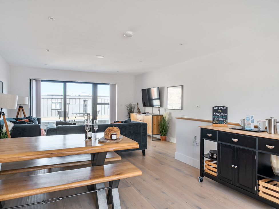 A living room with a dining table and seating area at Seascape in Newquay