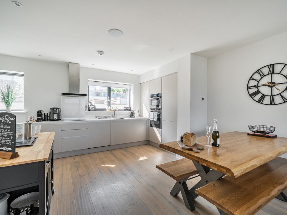 A kitchen with a table and chairs at Seascape in Newquay