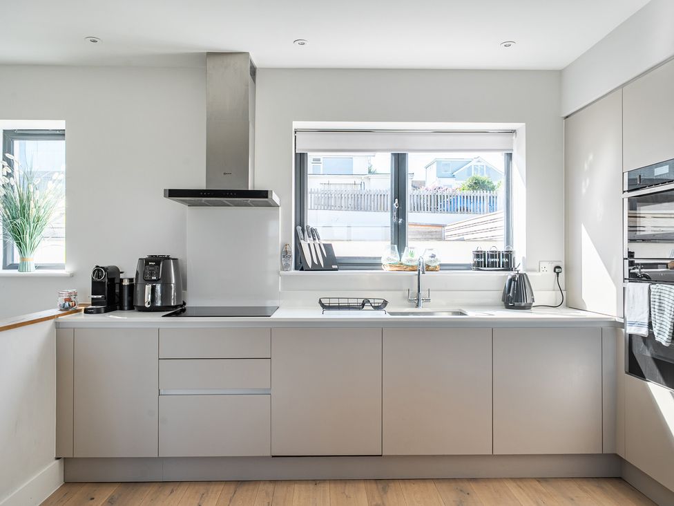 A kitchen with a sink and coffee maker at Seascape Newquay