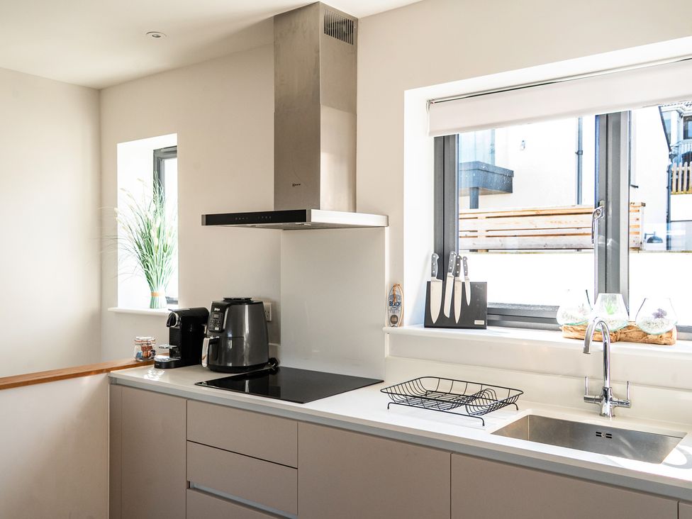 A kitchen with sink, counter, and coffee maker at Seascape in Newquay