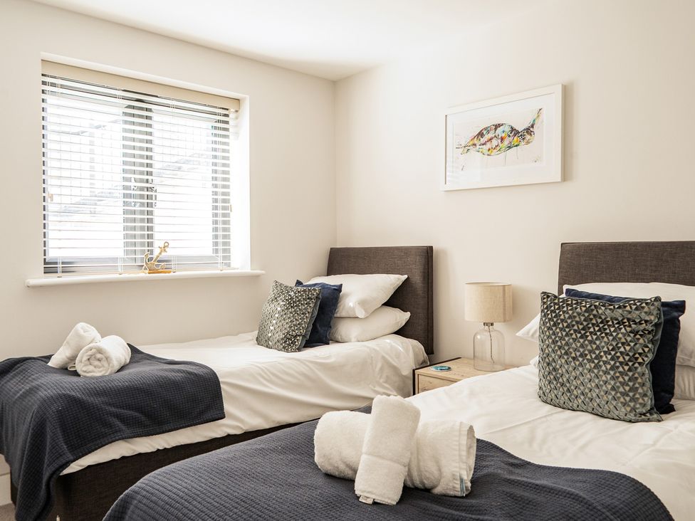 A bedroom with two beds and a window at Seascape in Newquay