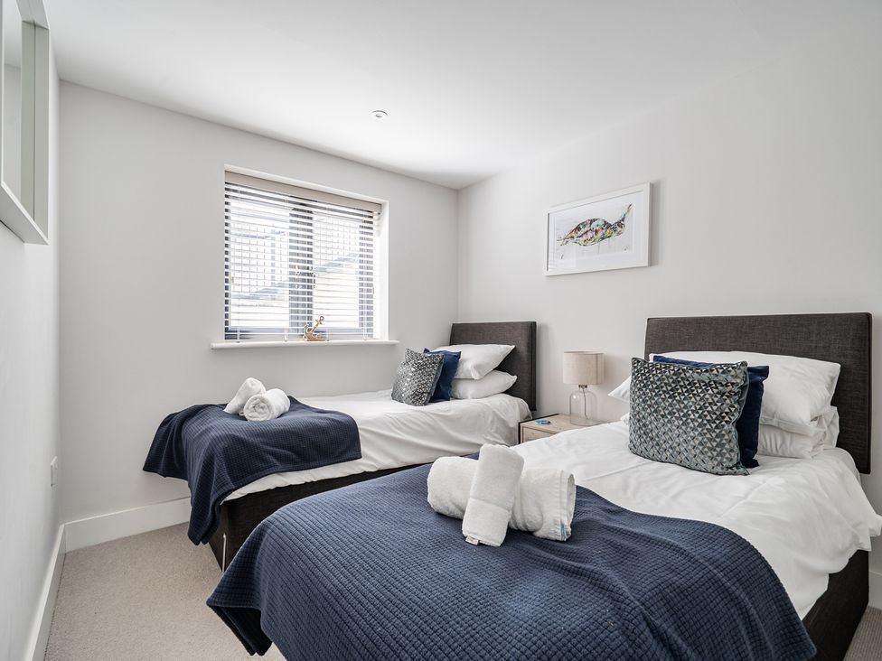 A bedroom with two beds and a nightstand at Seascape in Newquay
