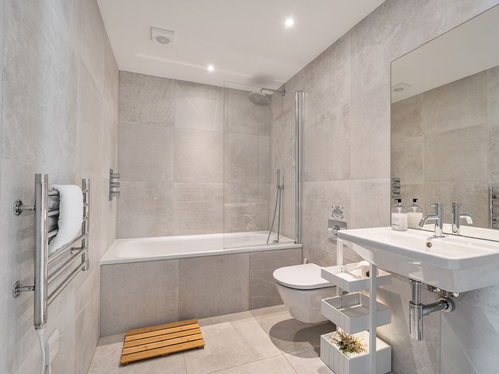 A bathroom with a bathtub, shower, toilet, and sink at Seascape in Newquay