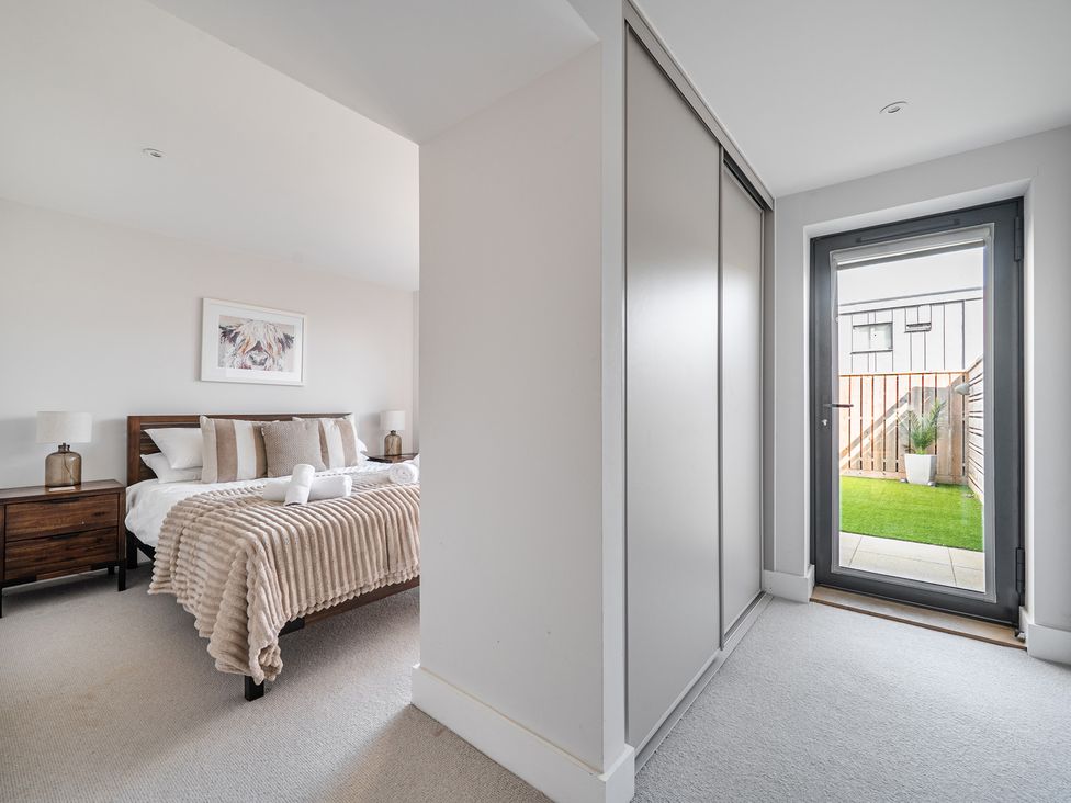 A bedroom with a bed and door to an outdoor area at Seascape in Newquay