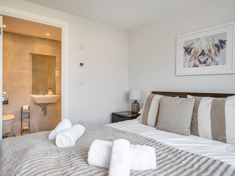 A bedroom with a bed and an attached bathroom at Seascape in Newquay
