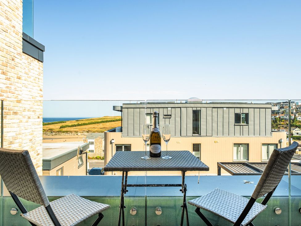 A balcony with table and chairs and a view at Seascape in Newquay