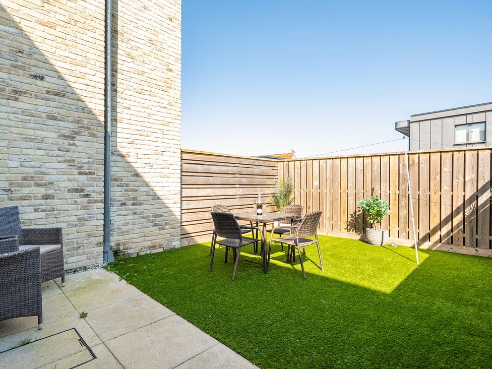 A garden area with a table and chairs at Seascape in Newquay