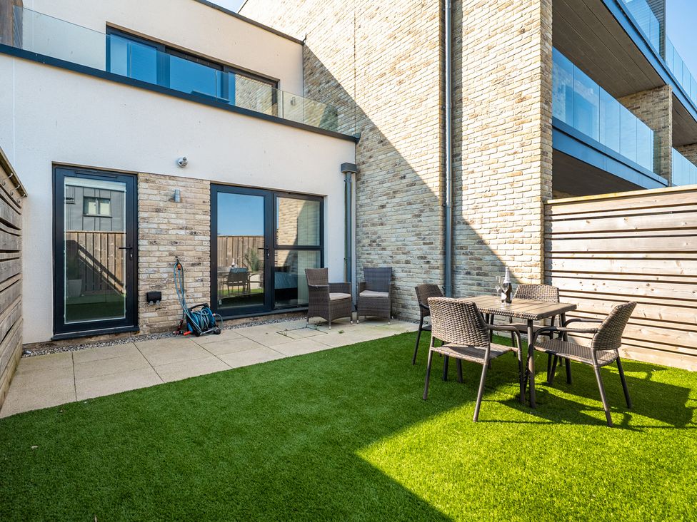 A garden with a table and chairs at Seascape in Newquay