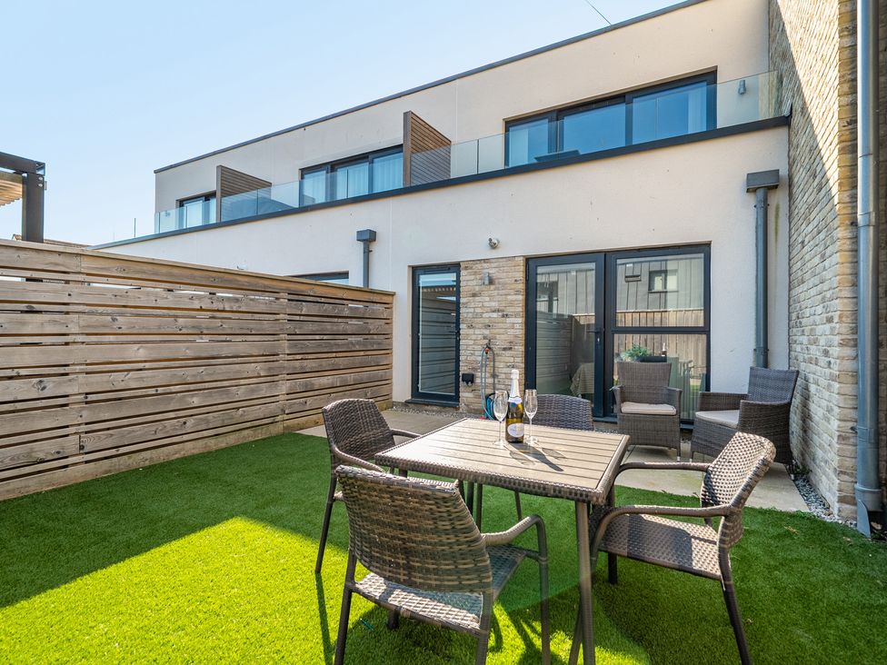 A garden with a table and chairs at Seascape in Newquay