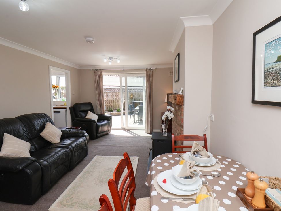 A living room with a sofa and dining area at Wheeldale Cottage in Goathland