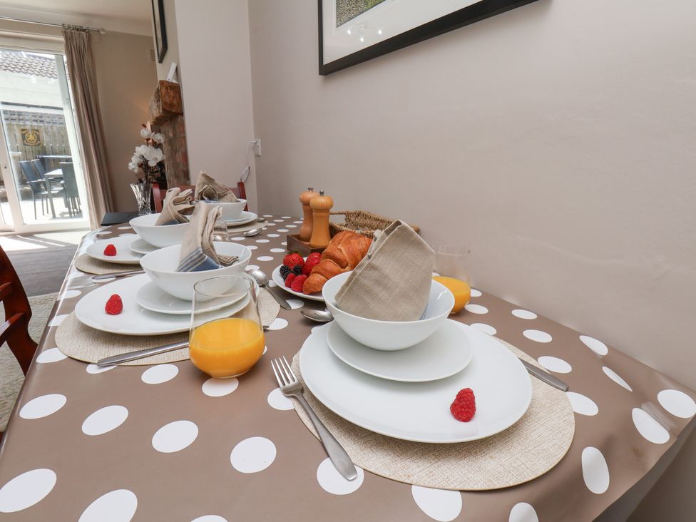 A dining room table set with plates and glasses at Wheeldale Cottage in Goathland