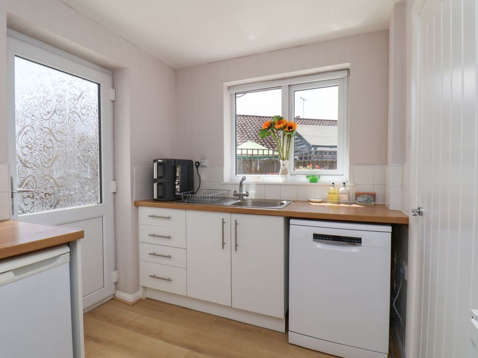 A kitchen with a sink and window at Wheeldale Cottage in Goathland