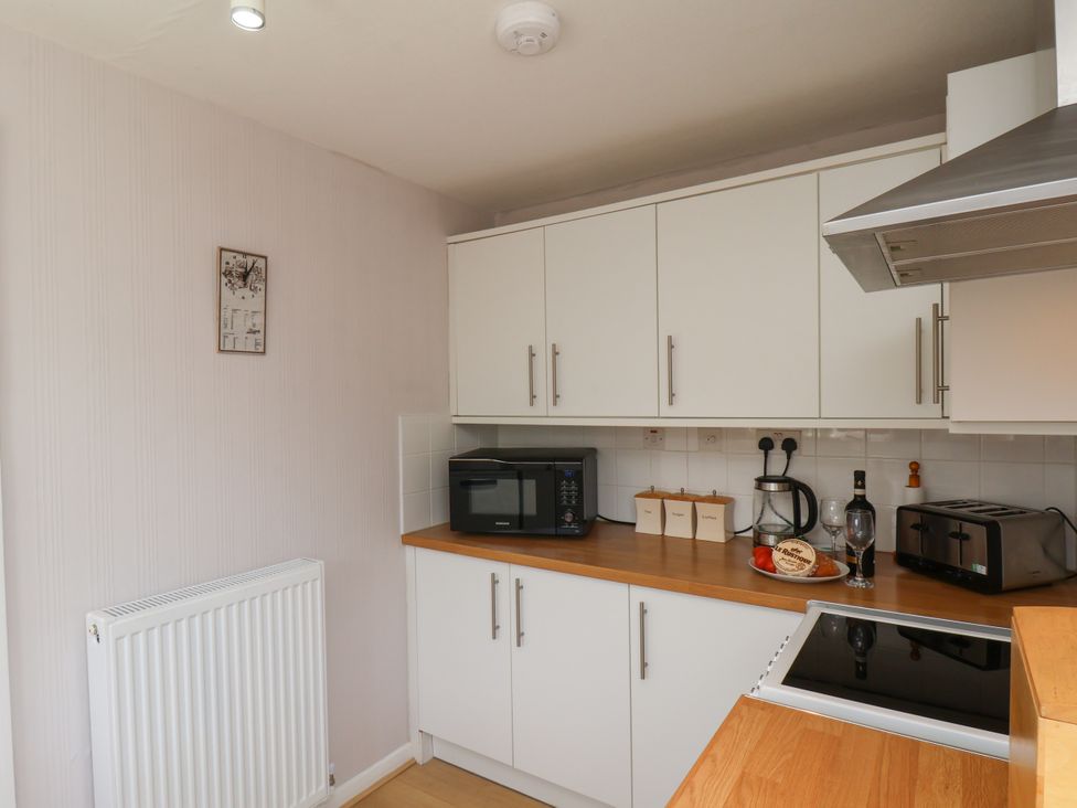 A kitchen with appliances and cabinets at Wheeldale Cottage in Goathland