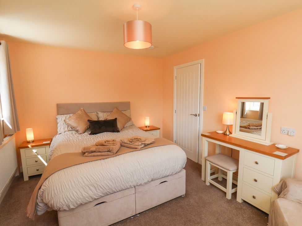 A bedroom with a bed and dressing table at Wheeldale Cottage in Goathland