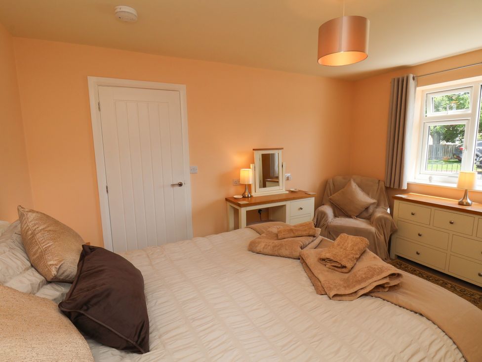 A bedroom with a bed and dresser at Wheeldale Cottage in Goathland