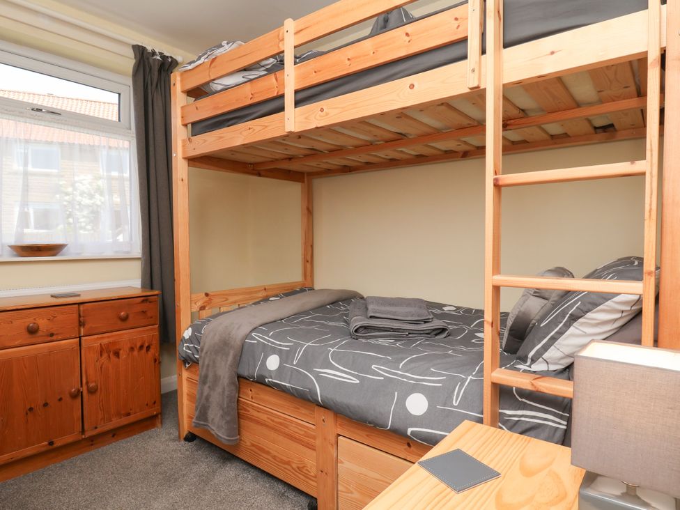 A bedroom with a bunk bed and a cabinet at Wheeldale Cottage in Goathland
