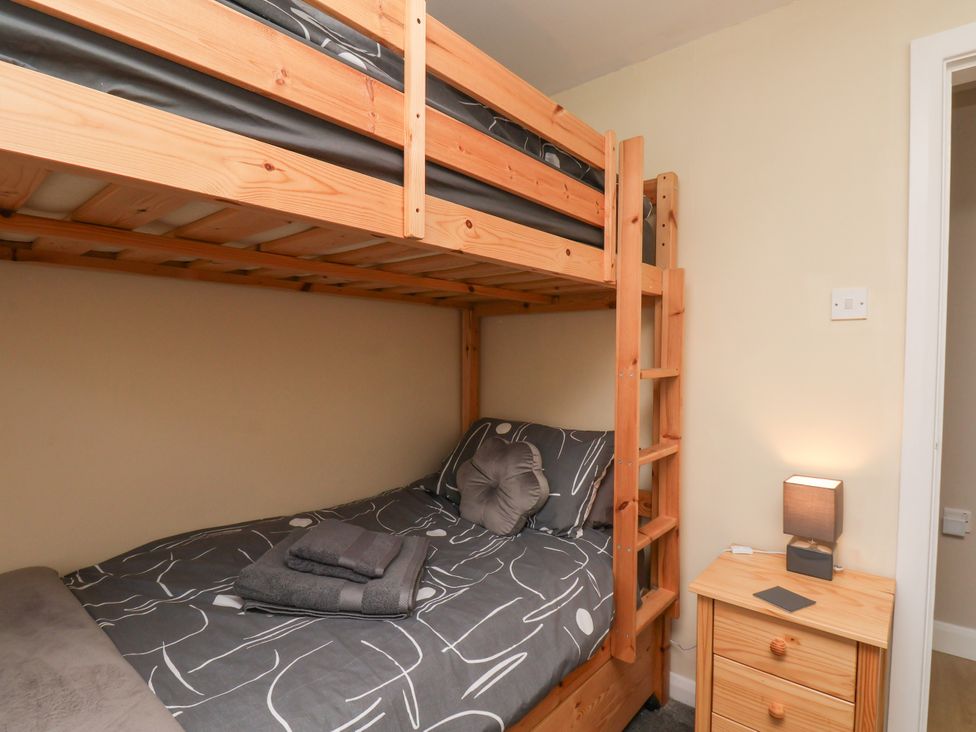 A bedroom with a bunk bed and bedside table at Wheeldale Cottage Goathland