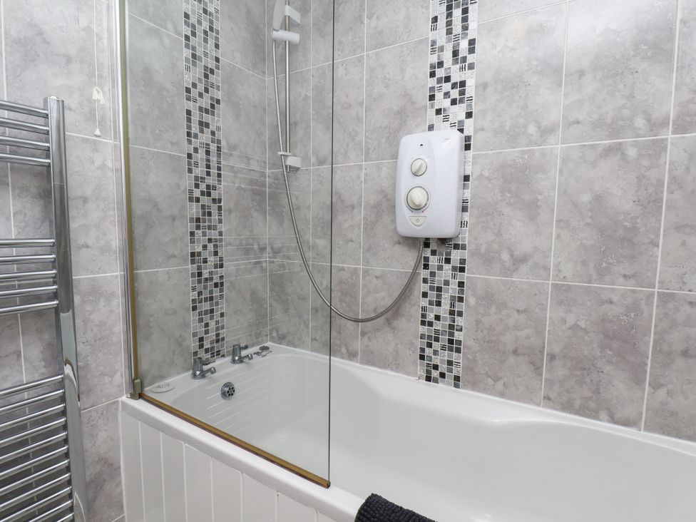 A bathroom with a bath tub and shower at Wheeldale Cottage in Goathland
