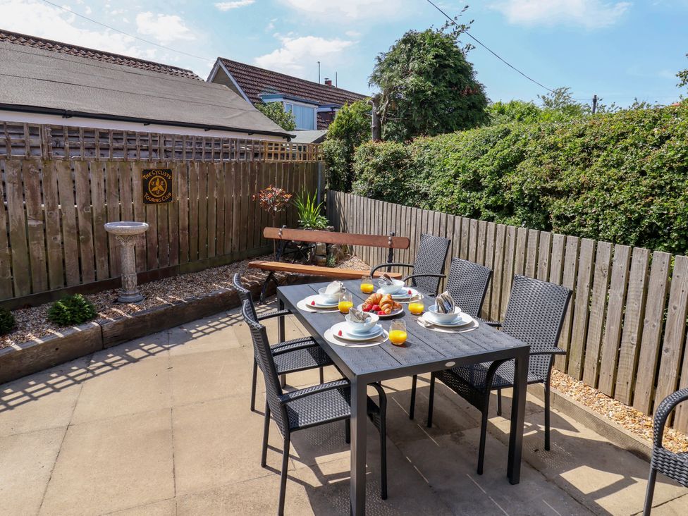 A garden with a dining table and chairs at Wheeldale Cottage in Goathland