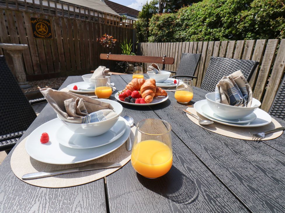 An outdoor dining area with plates and croissants at Wheeldale Cottage in Goathland
