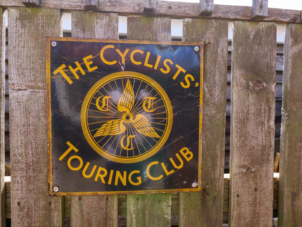 A sign for The Cyclists' Touring Club on a wooden fence