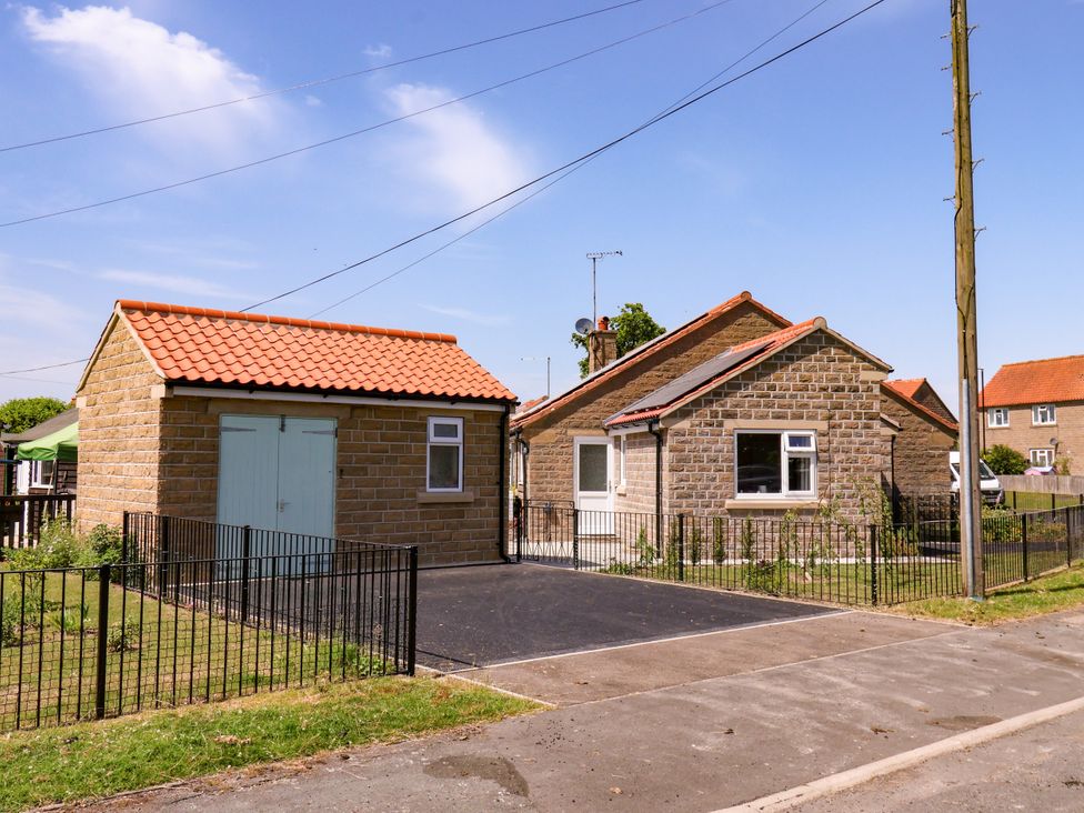 A house with a shed and fenced area at Wheeldale Cottage in Goathland